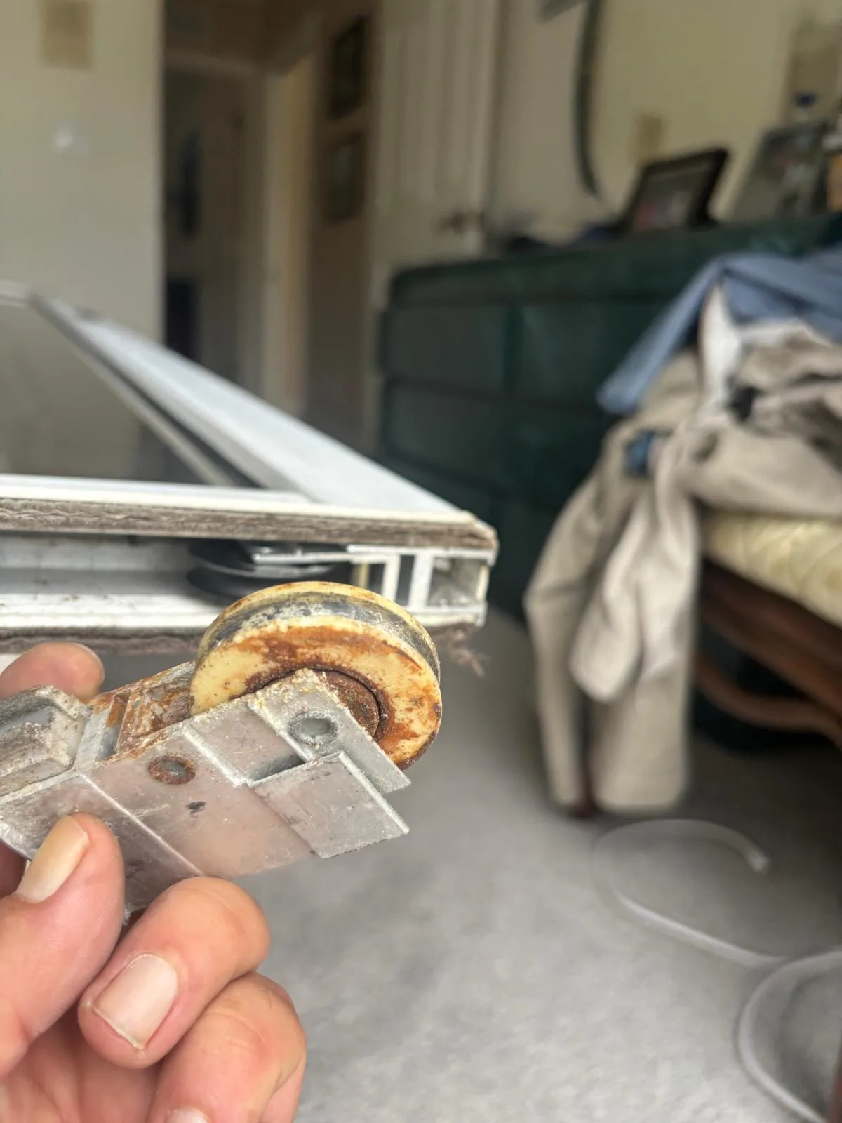 Technician removing old sliding door rollers during replacement