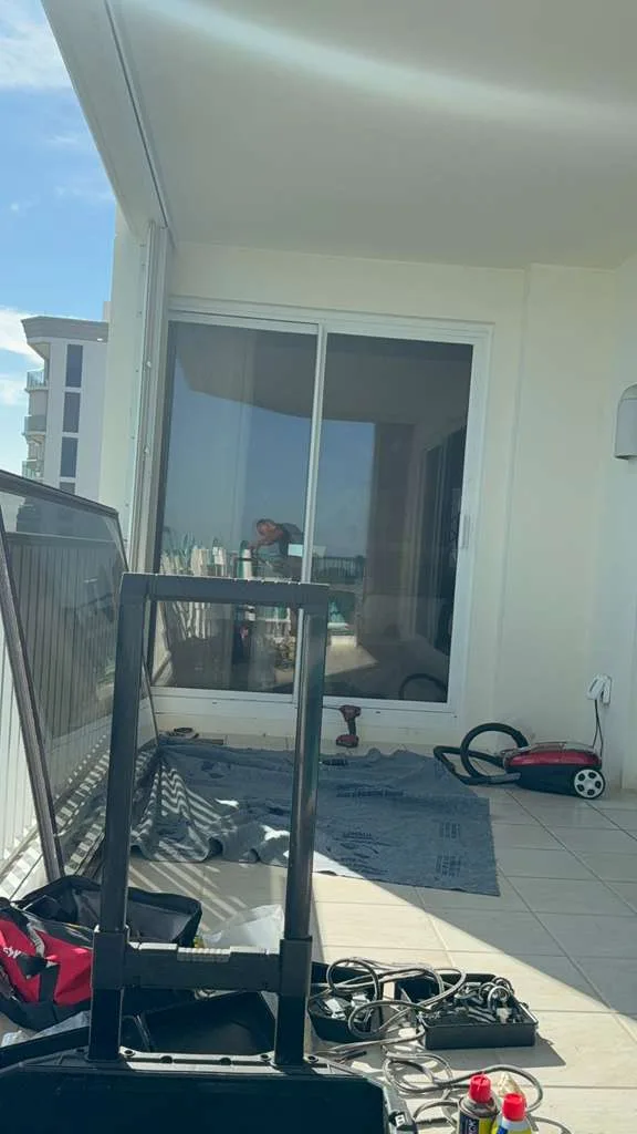 Technician repairing a sliding glass door at a Port Salerno waterfront home