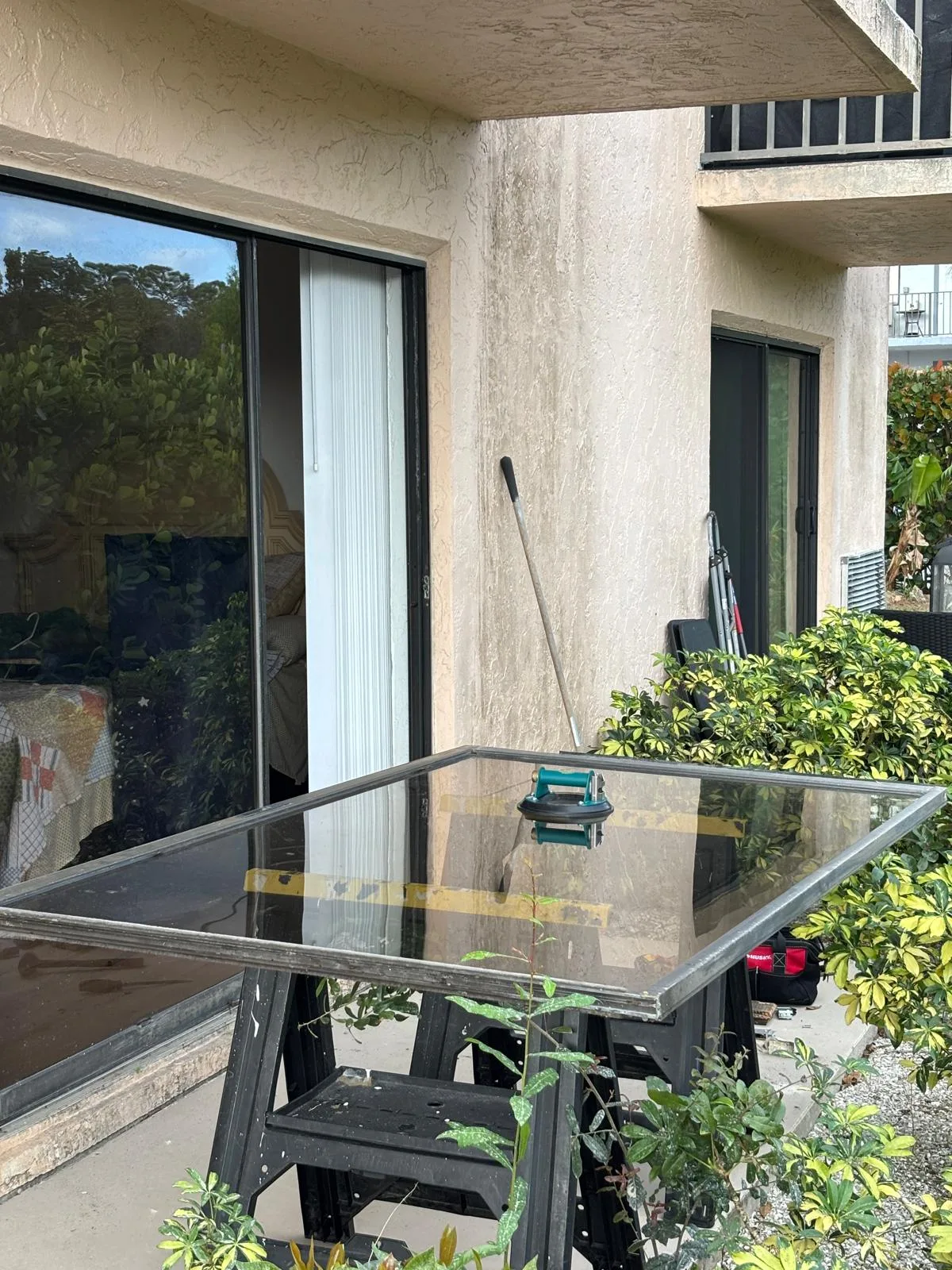 Sliding door panel set up on sawhorses for roller replacement